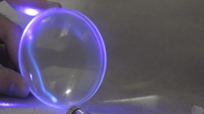Light from a laser reflected in an acrylic plastic lens